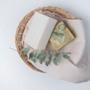 A natural, eco-friendly soap set with eucalyptus in a wicker basket, perfect for organic lifestyle promotions.
